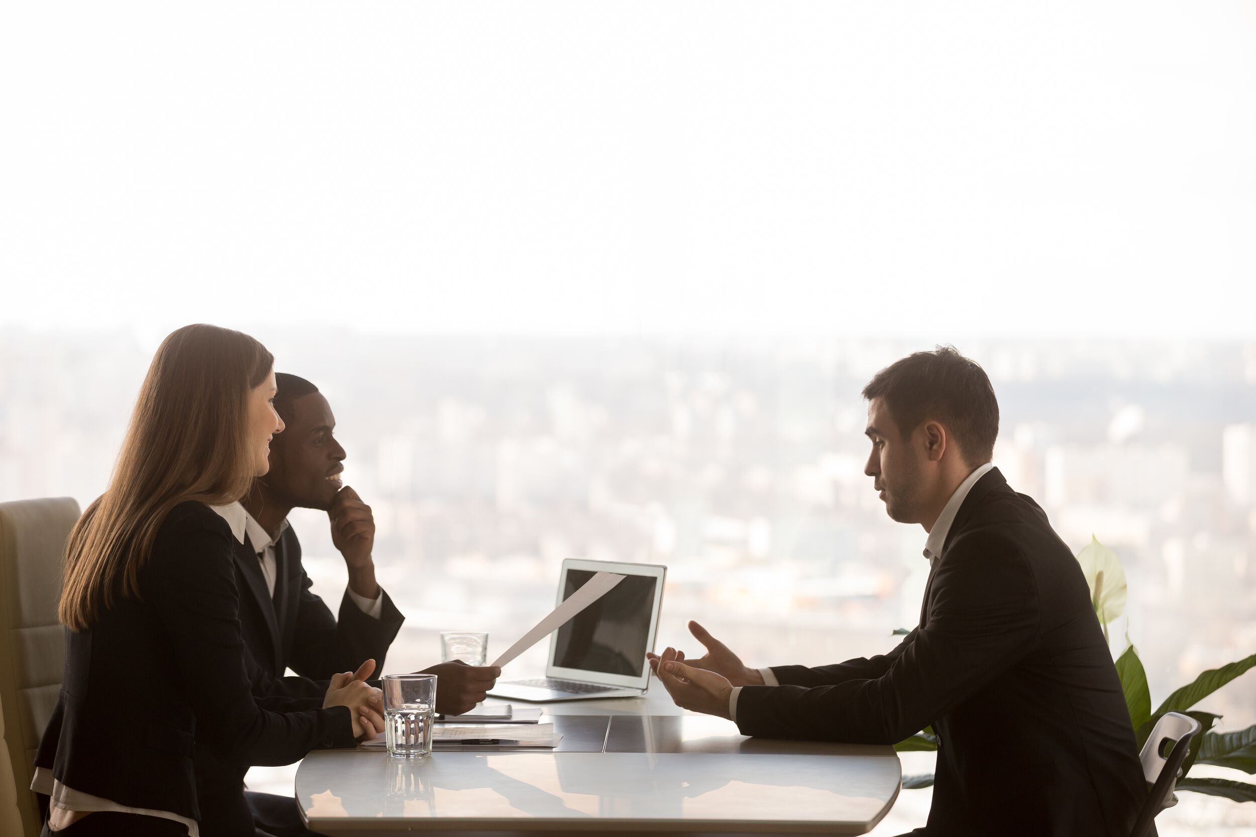 Coworkers meeting in front of a glass window.